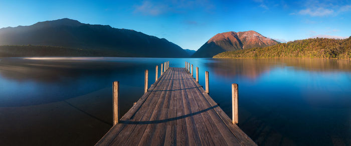 Scenic view of lake by mountains against sky