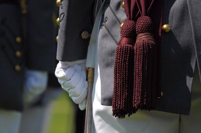 Midsection of man in uniform standing outdoors