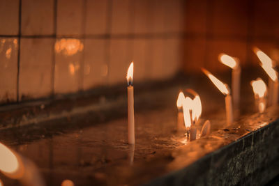 Close-up of lit candles in temple