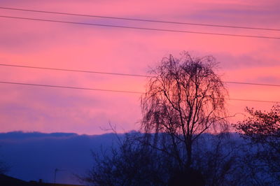 Silhouette of electricity pylon at sunset