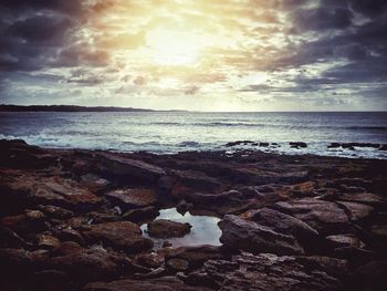 Scenic view of rocky beach against sky