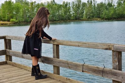 Woman standing on pier by lake