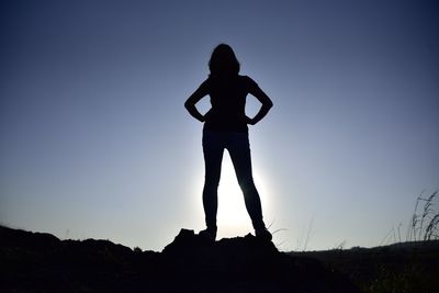 Silhouette woman standing against clear sky during sunset