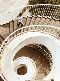 High angle view of woman walking on spiral staircase