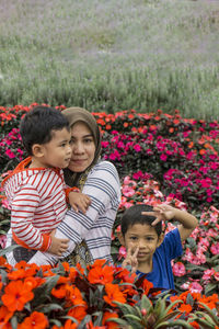 Portrait of mother and son with boy amidst flowering plants