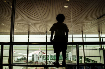 Rear view of silhouette man standing in corridor