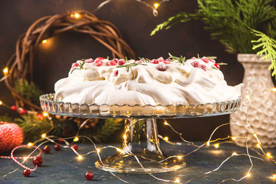View of cake with plant and christmas lighting on table