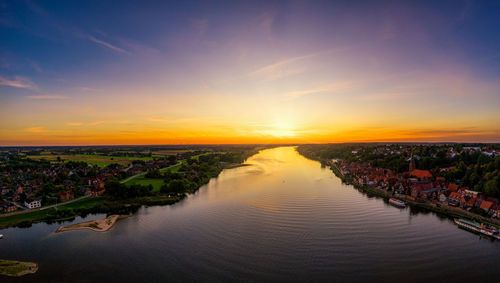 Scenic view of river against sky during sunset