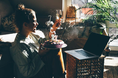 Woman with cake by table