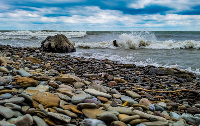 Pebbles on beach against sky