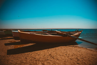 Boats moored on sea against clear sky