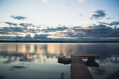 Pier on lake at sunset