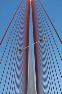 Low angle view of suspension bridge against blue sky