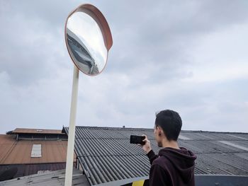 Man photographing against sky