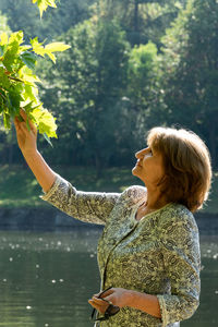 Midsection of woman standing by tree against plants
