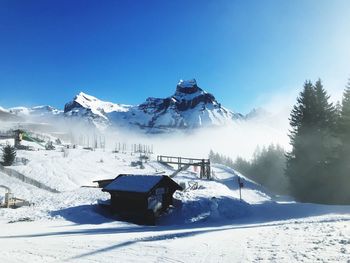 Snow covered mountains against clear blue sky