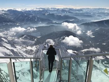 Man standing on snow covered mountain against sky