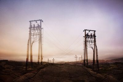 Electricity pylon on landscape against sky