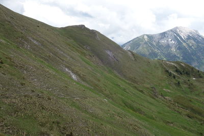 Scenic view of green landscape and mountains against sky