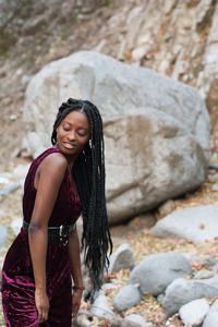 Portrait of smiling young woman standing on rock