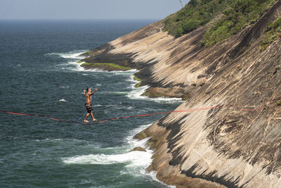 People on rock by sea