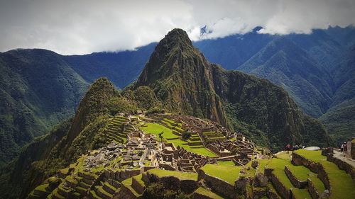 Panoramic view of green landscape against cloudy sky