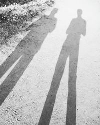 Shadow of man and woman standing on cobblestone street