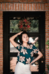 Portrait of thoughtful girl standing against door