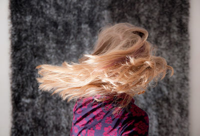 Side view of woman tossing blonde hair