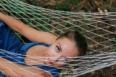 High angle portrait of woman resting in hammock