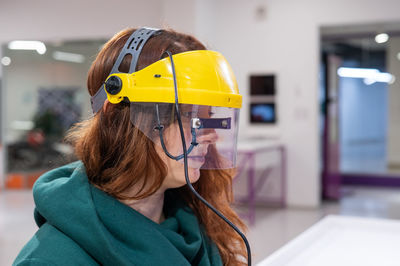 Woman wearing face shield in workshop