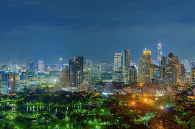 Illuminated buildings in city against sky at night