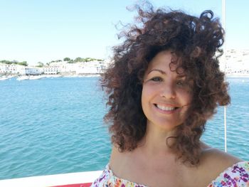 Portrait of smiling woman against sea