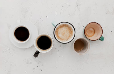 Top view on flat lay with many different coffee cups composition on gray white concrete background