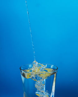 Close-up of drink in glass against blue background