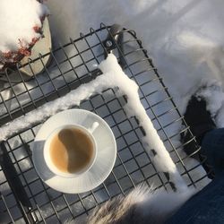 Directly above shot of coffee by person on snow covered field during winter