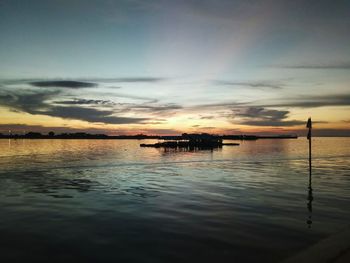 Silhouette boat in sea against sky during sunset