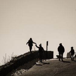 Silhouette men on road against sky