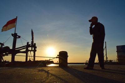 Silhouette people standing against sky during sunset