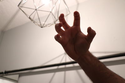 Close-up of hand touching ceiling