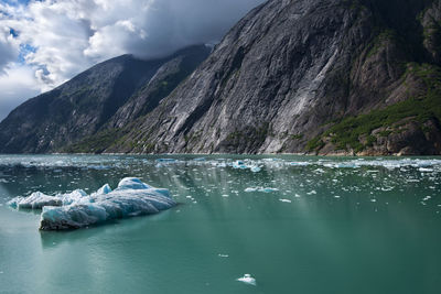 Scenic view of an iceberg against a mountain range