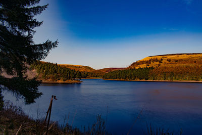 Scenic view of lake by mountain against sky