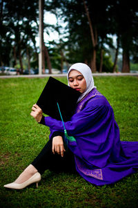 Young woman sitting on field