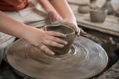 Midsection of man making pottery at workshop