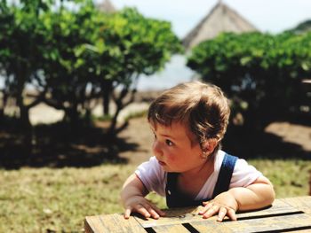 Close-up of cute baby boy by wooden crate