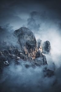 Scenic view of dolomites covered with fog against sky