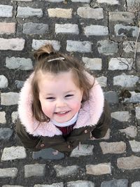 Portrait of smiling girl against wall