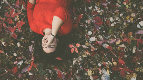 Low section of woman with autumn leaves on land