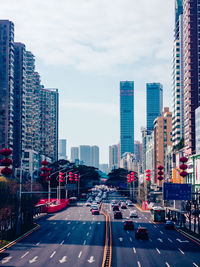 Traffic on road in city against sky