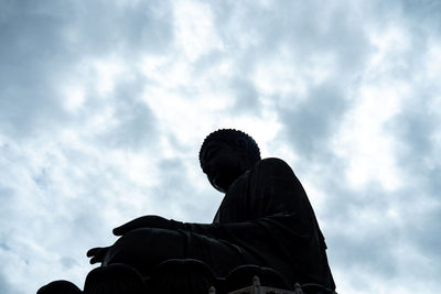 Low angle view of people sitting against sky